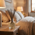 Small reed diffuser set on a bedside table